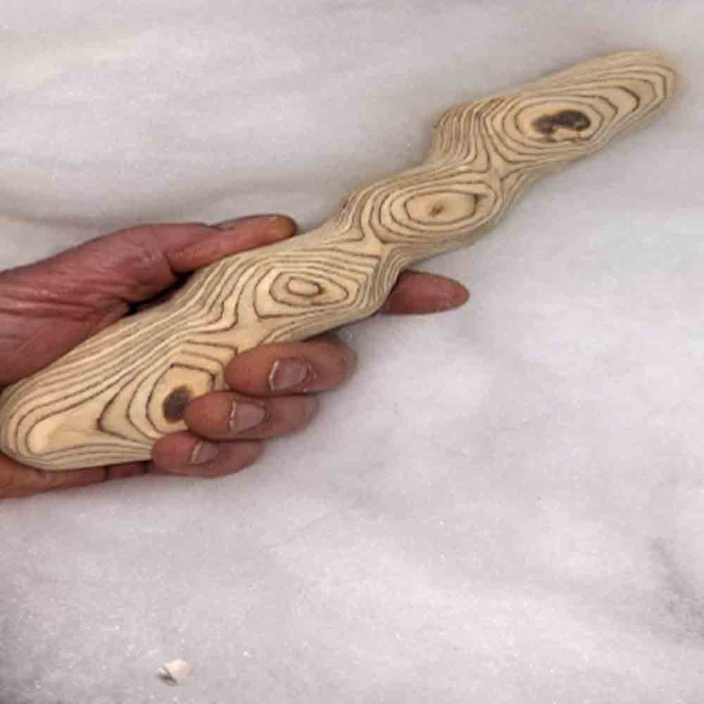 Handgefertigtes Holzunikat mit markanter Maserung, in einer Hand gehalten